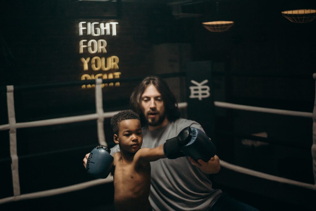Photo of a young child being taught to box