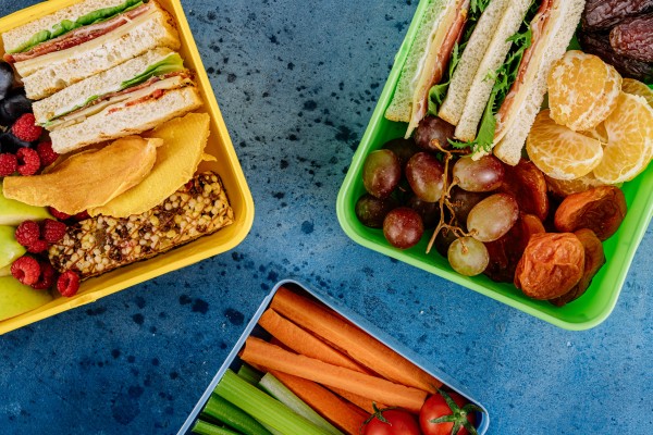 A photo of some healthy looking sandwiches and snacks in lunchboxes